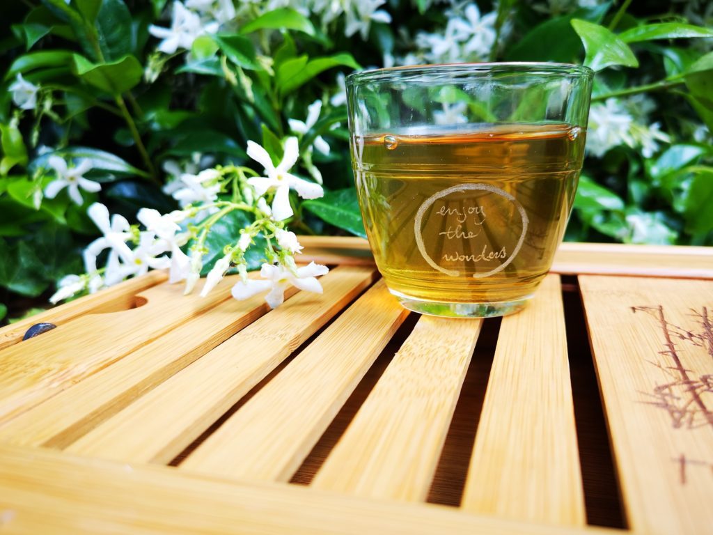 A cup of green tea to make DIY toner on bamboo table.