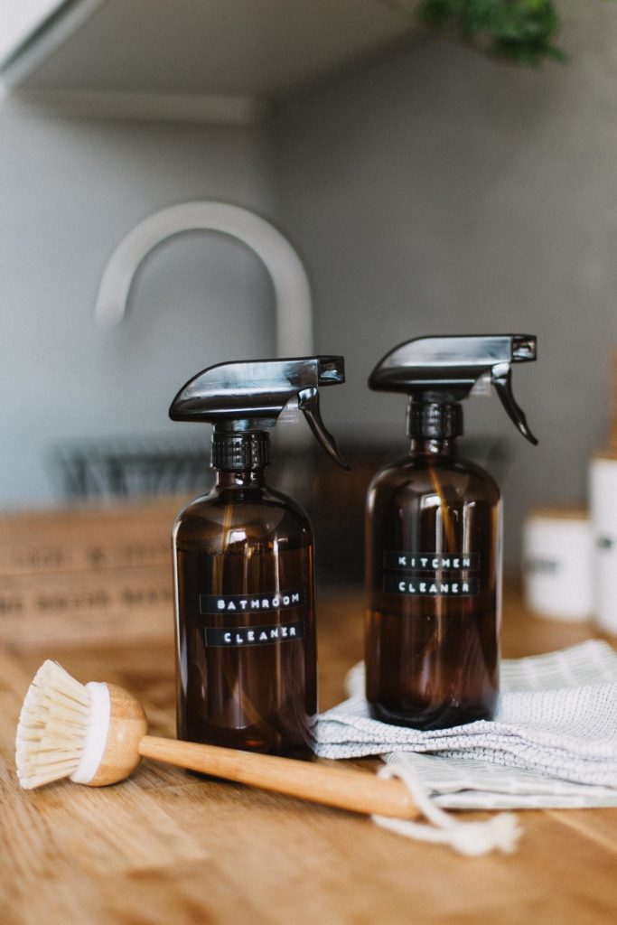 Two amber glass bottles with DIY cleaner and brush 